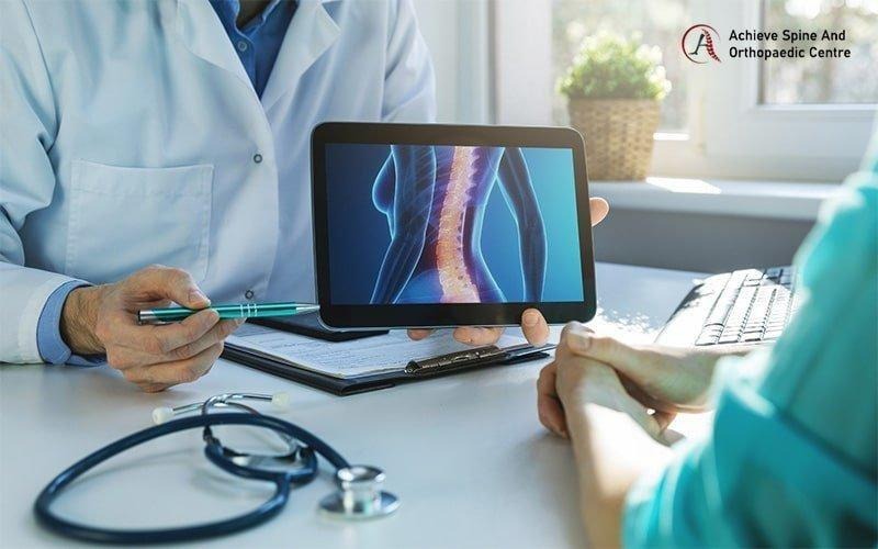 Bác sĩ giải thích cho bệnh nhân về các vấn đề cột sống và nguyên nhân gây đau lưng.